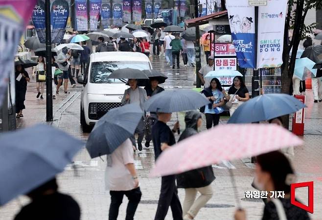 13일 중부지방에 가을 비가 내린 가운데 서울 명동에서 관광객들과 시민들이 우산을 들고 길을 가고 있다. 사진=허영한 기자 younghan@