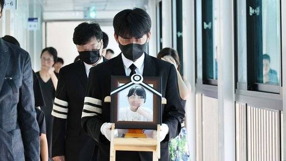 악성 민원으로 세상을 뜬 대전 초등 교사의 유족이 9일 오전 교사가 재직하던 초등학교에 교사의 영정사진을 들고 지나가고 있다. 연합뉴스