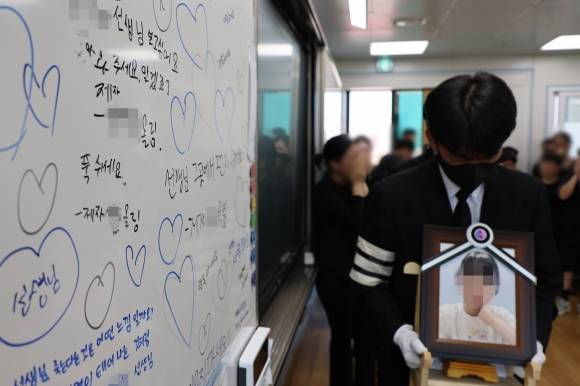 악성민원으로 세상을 뜬 대전 초등 교사의 유족들이 9일 오전, 교사가 재직하던 유성구 한 초등학교 교실에 영정사진을 들고 들어서고 있다. 2023.9.9 연합뉴스