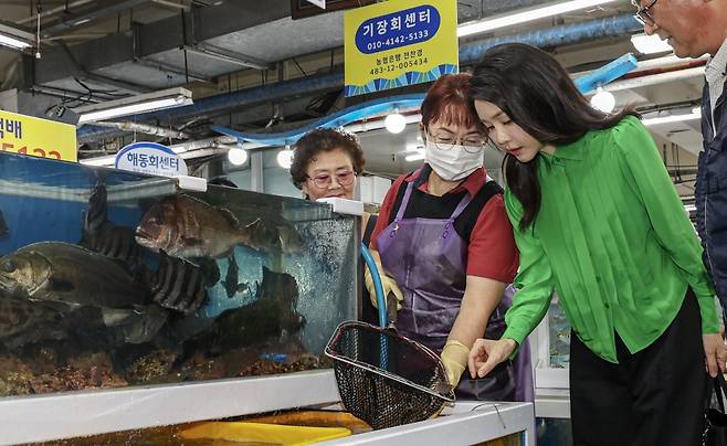 김건희 여사가 14일 부산 기장군 기장시장을 찾아 성게와 전복을 살펴보며 상인과 대화하고 있다. 2023.9.14. 뉴스1