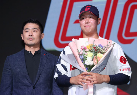 14일 열린 2024 KBO 신인 드래프트에서 롯데 자이언츠에 1라운드 3순위로 뽑힌 '투타 겸업' 경북고 전미르(오른쪽)가 성민규 구단 단장괗 함께 포즈를 취하고 있다. [사진=뉴시스]