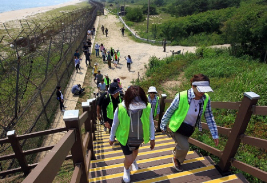 지난 2019년 4월27일 개방된  강원 고성과 인제를 연결하는 비무장지대(DMZ) 평화의 길 코스 탐방에 나선 방문객들이 2019년 6월26일  동해안  철책을 따라 걷고 있다. 연합뉴스