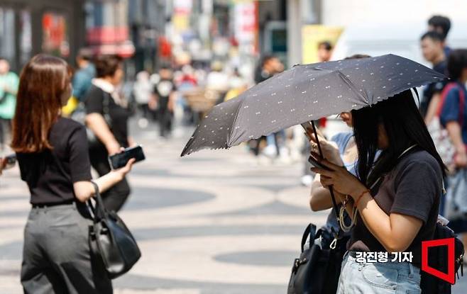 늦더위가 이어지고 있는 11일 서울 중구 명동에서 외국인 관광객이 양산으로 햇볕을 가리고 있다. 사진=강진형 기자aymsdream@