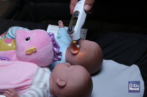 브라운 체온계 신제품의 야간모드를 활용해 어두운 밤 아이의 체온을 재고 있다. 이효상 기자 ⓒ베이비뉴스