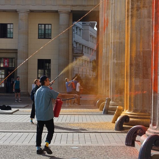 17일(현지시간) 기후 단체 ‘마지막 세대’ 운동가가 독일 베를린 브란덴부르크문에 페인트를 뿌리고 있다. ‘마지막 세대’ X