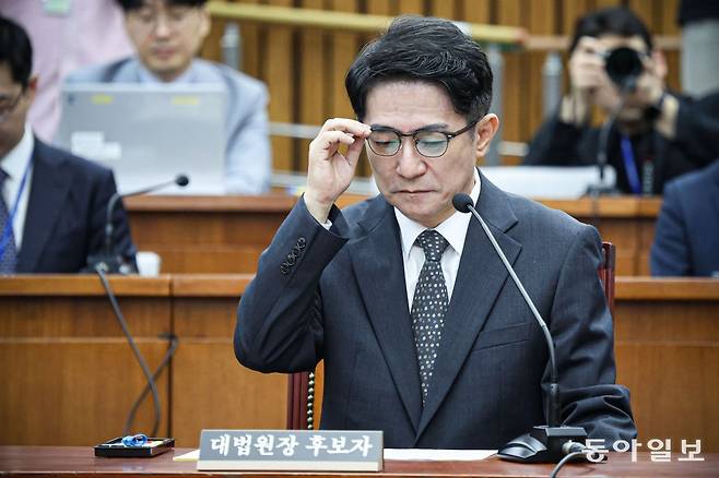 이균용 대법원장 후보자가 19일 오전 서울 여의도 국회에서 열린 대법원장 임명동의에 관한 인사청문특별위원회에 출석해 의원 질의를 듣는 도중 안경을 고쳐 쓰고 있다. 박형기 기자 oneshot@donga.com