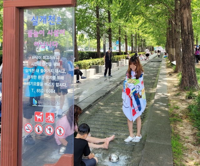 송상현광장 실개천에서 아이들이 즐거운 시간을 보내고 있다.