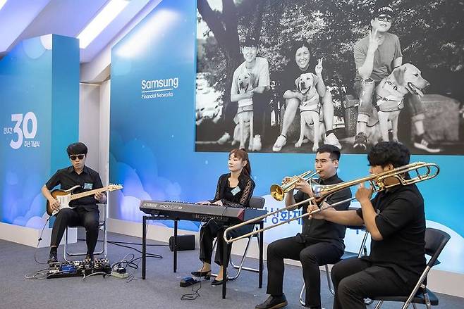 [서울=뉴시스] 19일 경기 용인시 삼성화재 안내견학교에서 열린 안내견 사업 30주년 기념식에 참석한 김예지 국민의힘 의원 및 안내견 파트너들이 축하 연주를 하고 있다. (사진=삼성전자 제공) 2023.09.19. photo@newsis.com *재판매 및 DB 금지