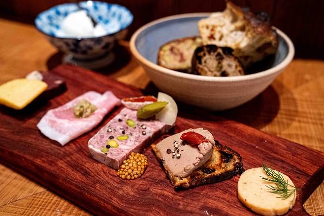 일본 도쿄 추오구 베이커리 뱅크가 운영하는 비스트로에서 제공하는 샤르퀴트리(염지 가공 돼지고기) 등 음식들. 무한 리필이 가능한 모둠 빵과 함께라면 “빵을 얼마든지 먹을 수 있는 꿈의 플레이트”라고 이케다 히로아키씨는 말했다.