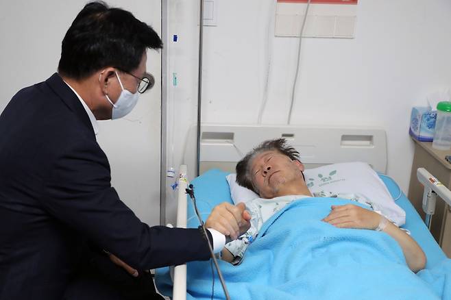 박광온 더불어민주당 원내대표가 21일 오전 서울 중랑구 녹색병원을 찾아 단식 중인 이재명 대표의 손을 잡고 대화하고 있다. /뉴스1