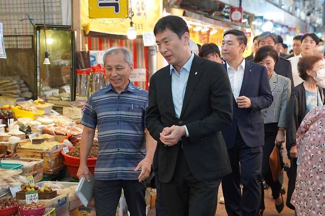 이복현 금감원장(앞줄 오른쪽)이 신원시장 상인회장과 대화를 나누며 시장을 둘러보고 있다. 사진=박문수 기자