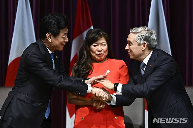 [오타와=AP/뉴시스]본과 캐나다 정부가 전기자동차(EV)용 배터리 공급망을 공동으로 만들기로 합의했다. 니시무라 야스토시(왼쪽) 일본 경제산업상이 21일(현지시간) 캐나다의 메리 응(가운데) 국제통상장관, 프랑수아-필립 샹파뉴 산업부 장관과 악수하고 있다. 2023.09.22.