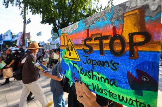 지난 9일 오후 서울 종로구 새문안로에서 열린 후쿠시마 오염수 해양투기 중단 범국민대회에서 한 참가자가 팻말을 들고 있다. 연합뉴스
