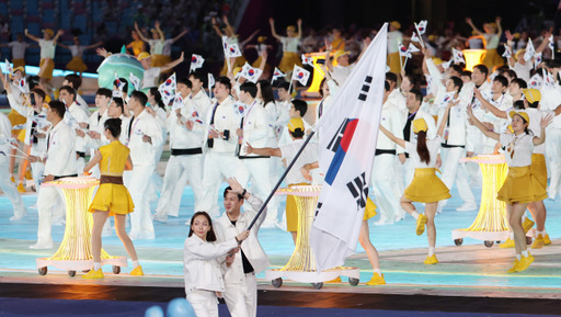 2022 항저우 아시안게임 개회식에서 대한민국 선수단 기수 구본길(펜싱)과 김서영(수영)이 태극기를 흔들며 입장하고 있다. 연합뉴스