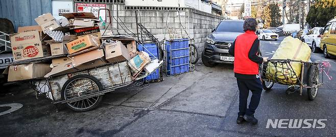 [서울=뉴시스] 정병혁 기자 = 10일 서울시내 한 골목에서 한 노인이 리어카를 옮기고 있다.. 2023.01.10. jhope@newsis.com