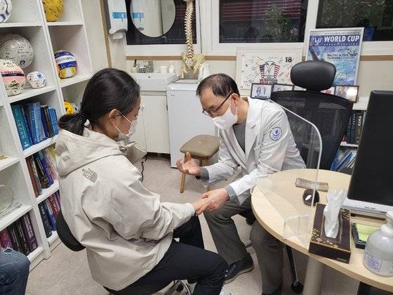 스포츠클라이밍 국가대표인 서채현 선수(왼쪽)가 나영무 솔병원 원장의 진료를 받고 있다. 서채현은 13년 전 김연아처럼 항저우 하늘의 가장 높은 곳까지 오르기 위해 오늘도 구슬땀을 흘리고 있다. [중앙포토]