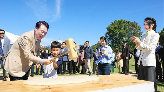 윤석열 대통령과 김건희 여사가 24일 서울 용산어린이정원에서 추석을 앞두고 열린 '추석맞이 팔도장터'를 찾아 어린이와 함께 떡메를 치고 있다. 사진 대통령실