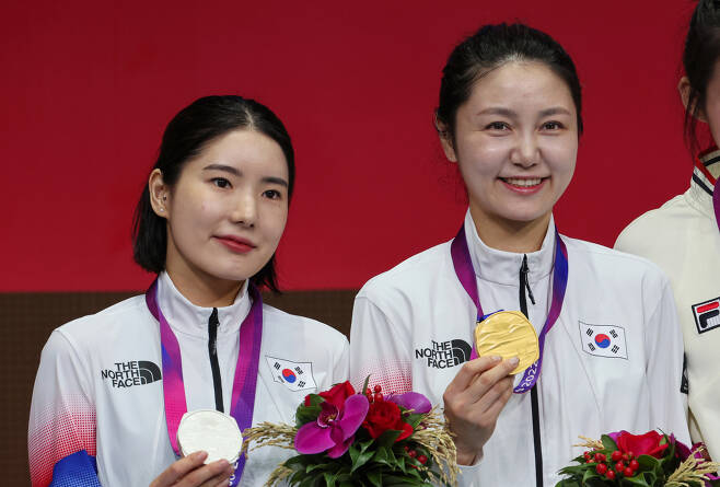 24일 중국 항저우 전자대학 체육관에서 열린 항저우 아시안게임 여자 에페 개인전에서 금메달를 딴 최인정(오른쪽)과 은메달을 딴 송세라가 기념 촬영하고 있다. [연합]