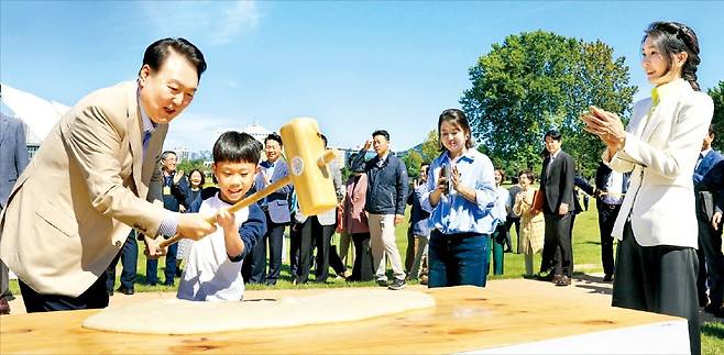 윤석열 대통령이 24일 서울 용산어린이정원에서 열린 추석 맞이 팔도장터를 깜짝 방문해 어린이와 떡메치기를 하고 있다.  대통령실 제공