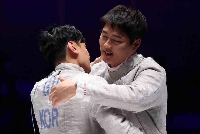 고생했어 오상욱(오른쪽)이 25일 항저우 아시안게임 펜싱 남자 사브르 개인전 결승에서 우승한 뒤 자신에게 패한 구본길을 포옹하고 있다. 항저우 | 연합뉴스