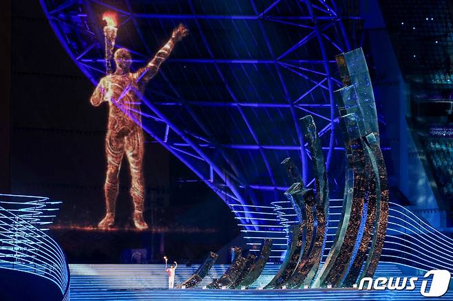 (항저우(중국)=뉴스1) 민경석 기자 = 23일 오후 중국 항저우 올림픽 스포츠센터 스타디움에서 열린 '2022 제19회 항저우 아시안게임' 개회식에서 도쿄 올림픽 남자 수영 200m 개인혼영 금메달리스트 왕순이 디지털 점화자와 함께 성화를 점화하고 있다. 2023.9.24/뉴스1  Copyright (C) 뉴스1. All rights reserved. 무단 전재 및 재배포,  AI학습 이용 금지.