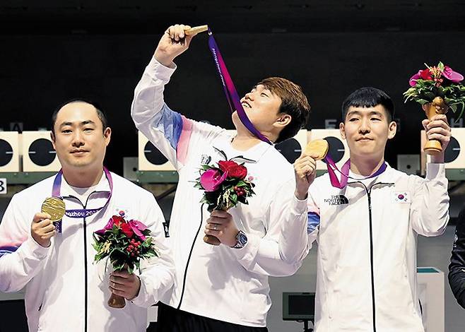 25일 오후 중국 항저우 푸양 인후 스포츠센터에서 열린 아시안게임 사격 남자 10m 러닝타깃 단체전 금메달을 따낸 하광철(왼쪽부터)과 정유진, 곽용빈이 시상대에 올라 기뻐하고 있다. /연합뉴스