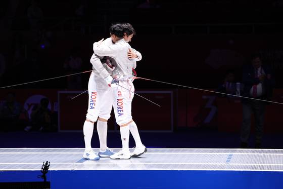 Oh Sang-uk and Gu Bon-gil embrace after Oh beating reigning champion Gu in the men's individual sabre finals at the Asian games at Hangzhou Dianzi University Gymnasium in Hangzhou, China on Monday.  [NEWS1]