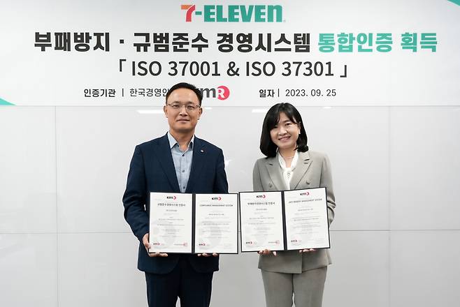 세븐일레븐이 편의점 업계 최초로 부패방지 경영시스템 ‘ISO 37001’과 규범준수 경영시스템 ‘ISO 37301’ 통합인증을 취득 했다. 최경호 세븐일레븐 대표이사(왼쪽)가 25일 열린 통합 인증 수여식에서 기념 촬영을 하고 있다.[세븐일레븐 제공]