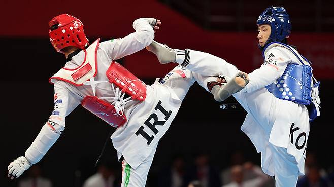 태권도 겨루기 남자 58㎏급 결승전에서 이란 마흐디 하지모사에이나포티에게 공격하는 장준