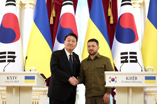 South Korean President Yoon Suk Yeol (left) and Ukrainian President Volodymyr Zelenskyy shake hands at Mariinsky Palace in Kyiv, Ukraine, after talks on July 15. (Presidential Office of South Korea)