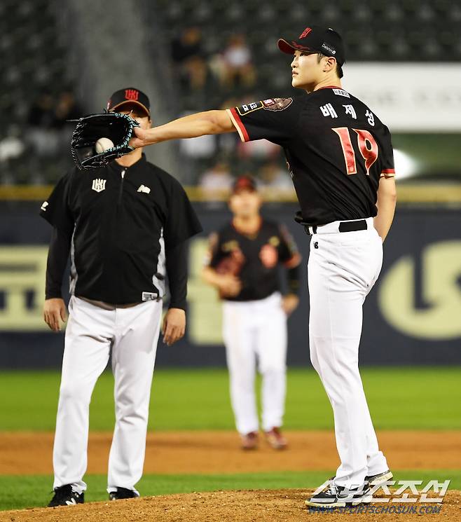 강습 타구에 다리를 맞은 KT 선발 배제성이 다시 일어나 연습 투구를 하고 있다.