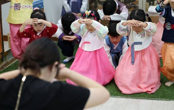 Children learn how to bow in a traditional way at a childcare center in Cheongju, North Chungcheong, on Tuesday. [YONHAP]