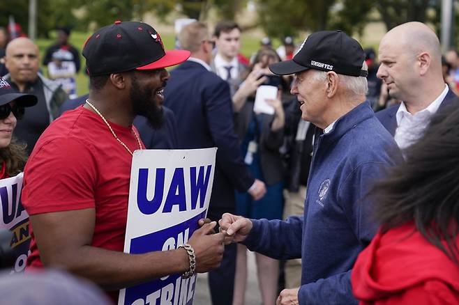 조 바이든 미국 대통령(오른쪽)이 26일(현지시간) 자동차 산업 중심지인 디트로이트 인근의 미시간주 벨빌에서 전미자동차노조(UAW)의 파업 현장을 방문하고 있다. [AP = 연합뉴스]