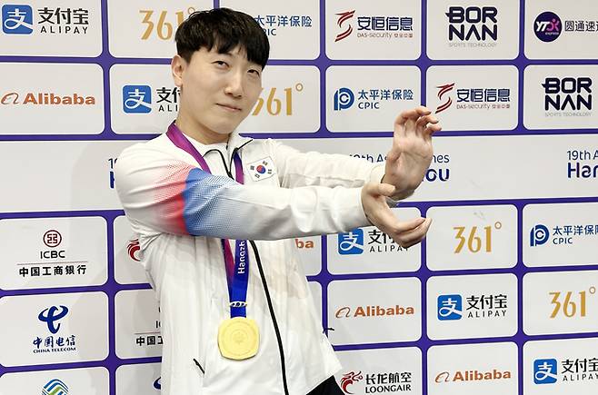 김관우가 지난 28일 중국 항저우 e스포츠센터에서 열린 2022 항저우 아시안게임(AG) 스트리트 파이터 V 결승전에서 대만의 샹여우린을 세트 점수 4-3으로 물리치고 금메달을 획득한 뒤 공동취재구역(믹스트존)에서 취재진을 향해 포즈를 취하고 있다. 베가 한 우물만 판 선수라 장풍을 싫어하지만 이날 만큼은 기꺼이 포즈를 취했다. 연합뉴스