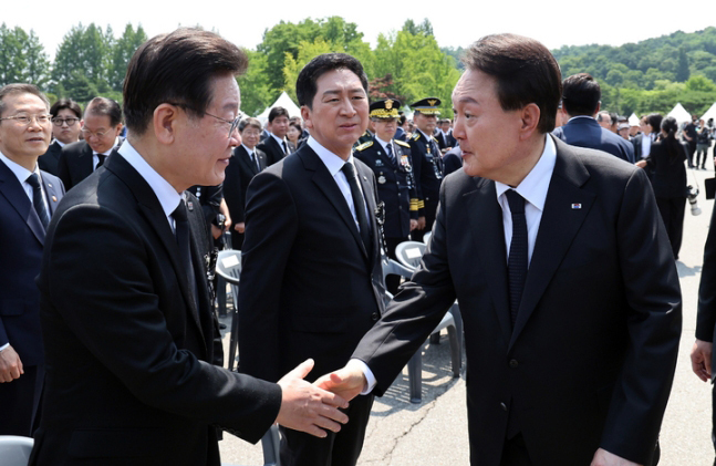 윤석열 대통령이 지난6월6일 서울 동작구 국립서울현충원에서 열린 제68회 현충일 추념식을 마친 뒤 이재명 더불어민주당 대표와 악수하고 있다. 뉴시스