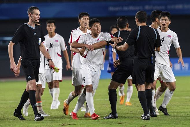 북한 남자축구 대표팀이 일본에게 패한 뒤 주심에게 거칠게 항의하고 있다. 사진=AP PHOTO