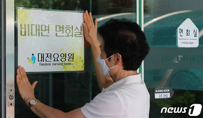 20일 오후 대전 서구 대전요양원에서 직원이 비접촉면회실 안내 문구를 붙이고 있다. /뉴스1 ⓒ News1 김기태 기자