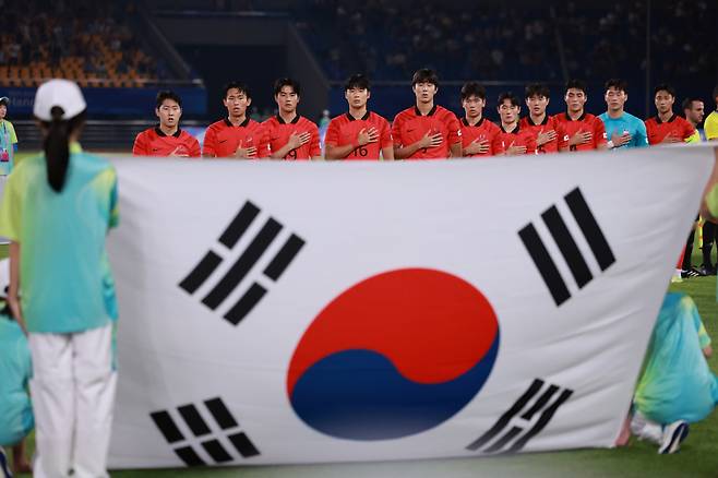 지난 27일 열린 2022 항저우 아시안게임 남자축구 16강전 대한민국과 키르기스스탄의 경기에서 대한민국 선수들이 국기에 대한 경례를 하고 있다. [연합]