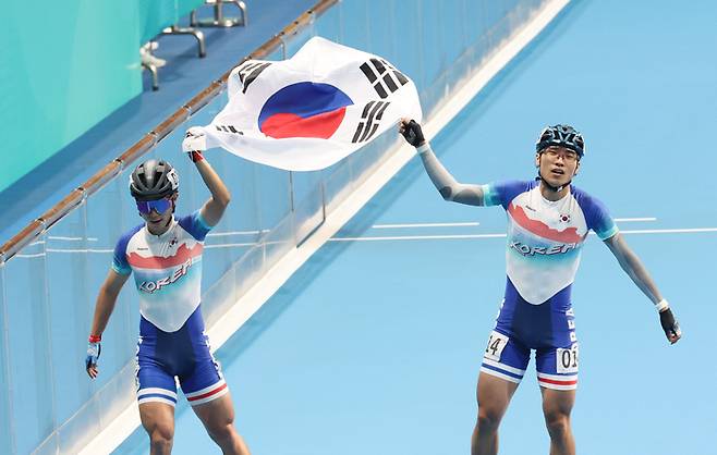 1일 중국 항저우 첸탕 롤러스포츠 센터에서 열린 19회 항저우 아시안게임 롤러스케이트 남자 스피드 1,000ｍ 결승에서 금메달을 차지한 최광호(오른쪽)와 은메달을 차지한 정철원이 태극기를 들고 경기장을 돌고 있다. 2023.10.1 연합뉴스
