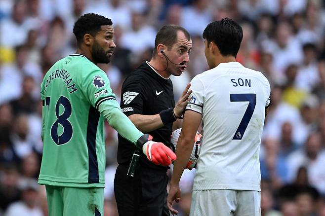 Sheffield United's English goalkeeper #18 Wes Foderingham (L) and Tottenham Hotspur's South Korean striker #07 Son Heung-Min (R) have words with English referee Peter Bankes (C) during the English Premier League football match between Tottenham Hotspur and Sheffield United at Tottenham Hotspur Stadium in London, on September 16, 2023. (Photo by JUSTIN TALLIS / AFP) / RESTRICTED TO EDITORIAL USE. No use with unauthorized audio, video, data, fixture lists, club/league logos or 'live' services. Online in-match use limited to 120 images. An additional 40 images may be used in extra time. No video emulation. Social media in-match use limited to 120 images. An additional 40 images may be used in extra time. No use in betting publications, games or single club/league/player publications. /