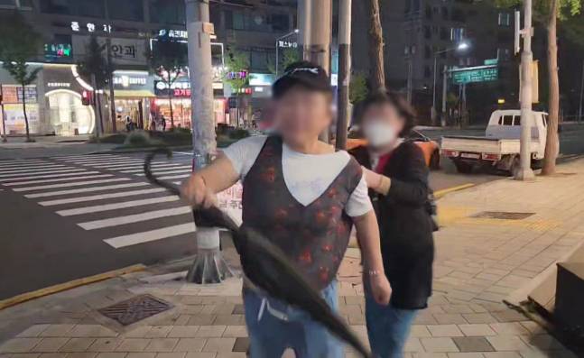 지난달 30일 오후 구청장 선거 유세 중이던 서울 강서구 방화동 인근에서 김태우 국민의힘 후보자 측 선거운동원에게 우산을 휘두르며 돌진하고 있는 50대 여성의 모습. 김태우 후보 캠프 제공