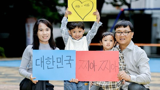 추석을 사흘 앞둔 지난달 26일 강민구 한국찌아찌아문화교류협회 홍보팀장(오른쪽)과 아내 뜨리(왼쪽)가 아들 하늘, 딸 아름이와 함께 충북 청주의 한 놀이터에서 직접 쓴 팻말을 들고 있다. 프리랜서 김성태