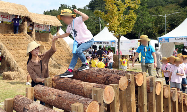 완주 와일드푸드 축제에서 어린이들이 통나무 다리를 조심스럽게 건너는 체험을 하고 있다. 완주군 제공