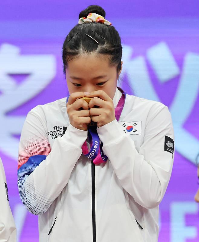▲ 2022 항저우 아시안게임 탁구 여자 복식 금메달에 입맞추는 신유빈 ⓒ연합뉴스