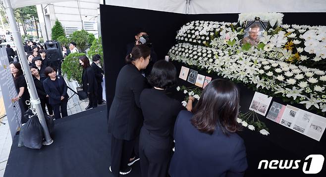 대한간호협회 관계자 및 간호사들이 4일 오전 서울 중구 동호로 대한간호협회회관 앞에 마련된 고 마가렛 피사렉 국민 분향소에서 열린 추모식에서 헌화하고 있다. 2023.10.4/뉴스1 ⓒ News1 박정호 기자