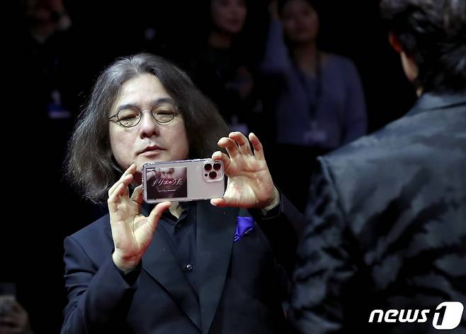 이와이 슌지 감독이 4일 오후 부산 해운대구 영화의전당에서 열린 ‘제28회 부산국제영화제’(BIFF) 개막식 레드카펫 행사에서 함께 온 배우들을 촬영 하고 있다. ⓒ News1 권현진 기자