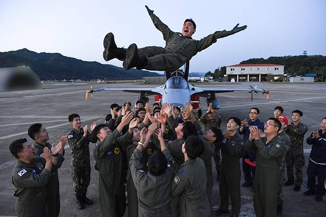 김남영 소령(가운데)이 5일 오후 FA-50 10만 시간을 달성하는 비행을 마치고 부대원들의 축하를 받고 있다. 사진 공군.