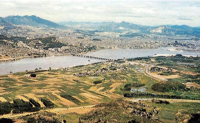 1950년대 상공에서 바라본 서울과 한강 일대 전경. 강남 대부분이 논밭인 것과 대비되어 강북에는 빼곡하게 건물과 주택이 들어서 있다. [압구정향우회]