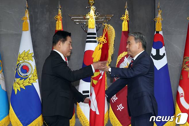 신원식 신임 국방부 장관(왼쪽)이 7일 서울 용산구 국방부 청사에서 열린 제48·49대 국방부장관 이·취임식에서 이종섭 국방부 장관에게 국방부기를 이양 받고 있다. (국방부 제공) 2023.10.7/뉴스1