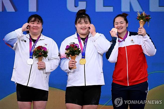 박혜정과 손영희의 볼 하트 (항저우 AFP=연합뉴스) 박혜정(가운데)이 7일 중국 저장성 항저우 샤오산 스포츠센터에서 열린 2022 항저우 아시안게임 역도 여자 87㎏ 이상급 경기에서 우승한 뒤, 2위 손영희(왼쪽)와 '볼 하트'를 만들고 있다.